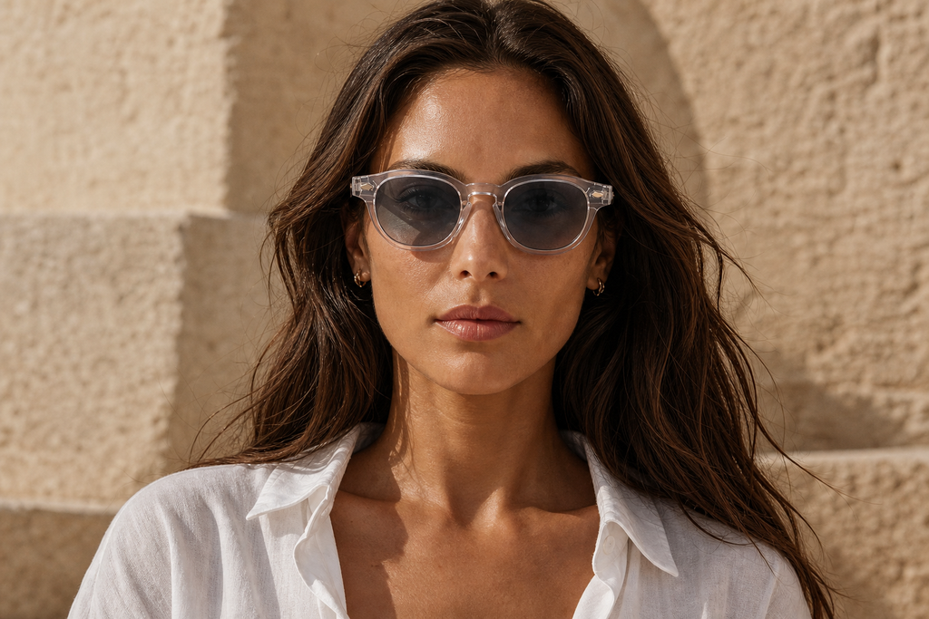 Lunettes de soleil Ushuaïa portées par une femme, monture cristal transparente et verres gris, style moderne
