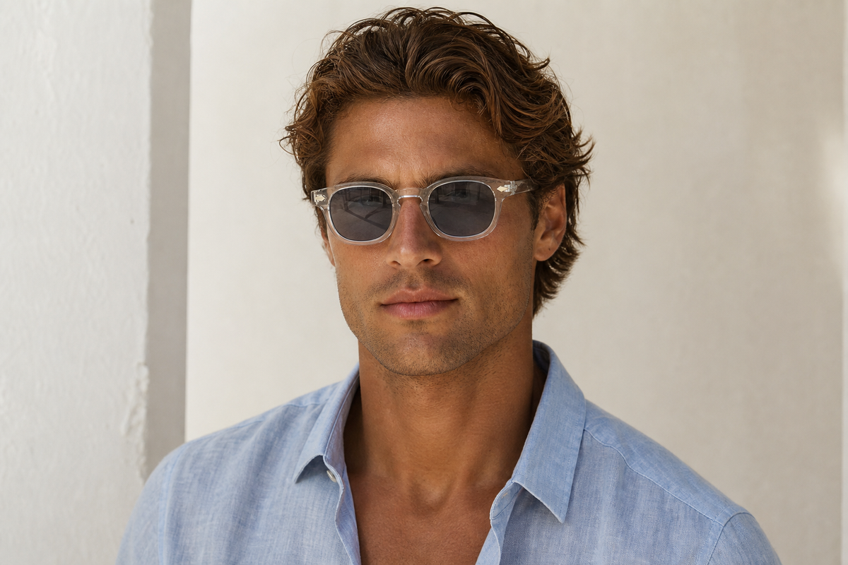 Lunettes de soleil Ushuaïa portées par un homme, monture cristal et verres gris fumés, look solaire léger